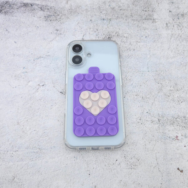 Lavendelfarbige Handyhalterung mit Saugnäpfen und cremefarbigen Herz an transparenter Handyhülle befestigt, stabiler Halt auf glatten Flächen