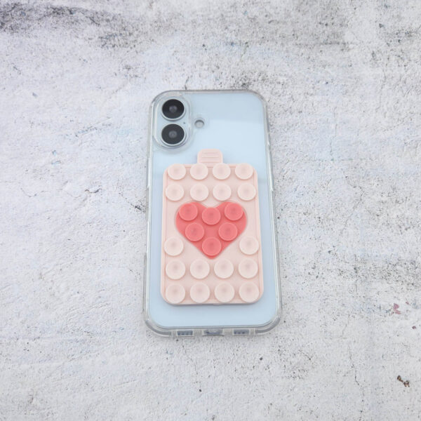 Noppie-Heart-Patch in Soft Nude mit Peach-Herz als suction cup phone holder auf einer Smartphone-Hülle, Silikonhalterung mit sicherem Halt